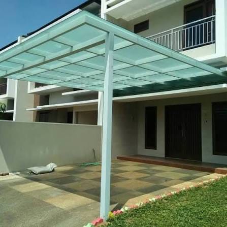 Kaca tempered pada kanopi dengan rangka putih di depan rumah