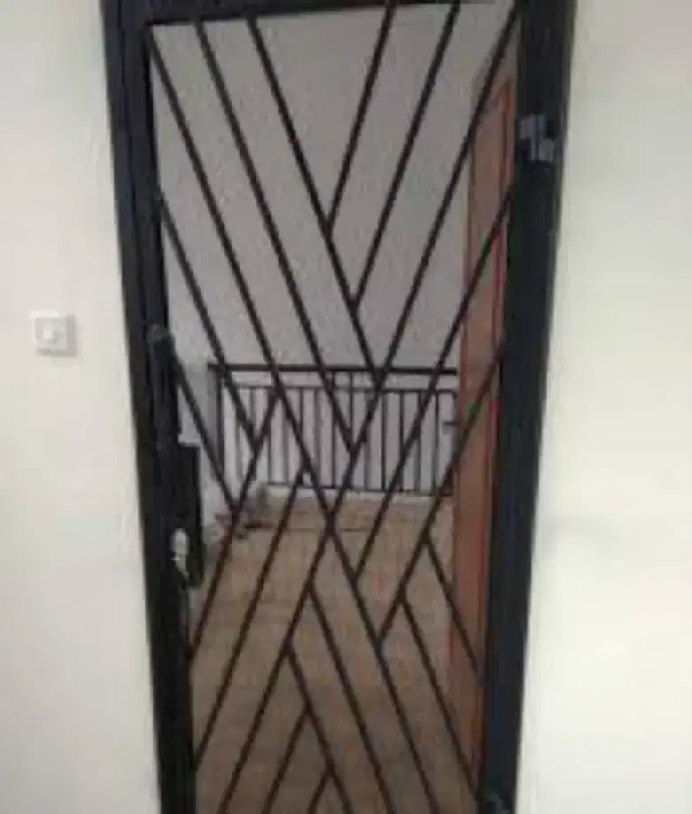 Teralis pintu hollow hitam dengan susunan garis diagonal